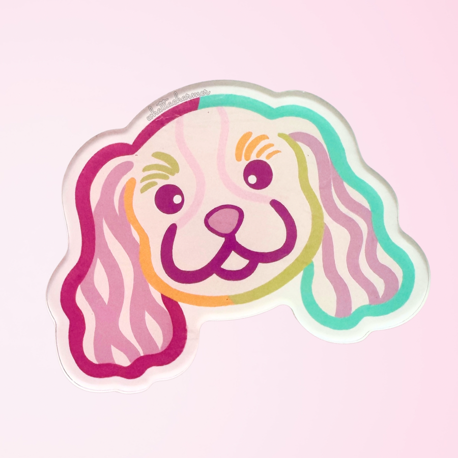 Cartoon Cavalier King Charles Spaniel dog face with colorful outlines on a pink background